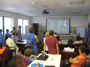 Campers and their parents watch a video presentation.